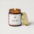 Clear Mind soy candle jar with gold lid, lit wick; label visible
