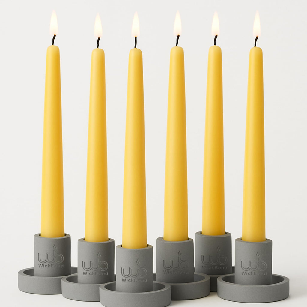 Dripless tapered candles in yellow wax with black wicks and flames, set of 7