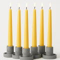 Dripless tapered candles in yellow wax with black wicks and flames, set of 7