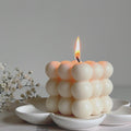 Bubble soy wax cube candle with white clustered wax balls and an upright flame