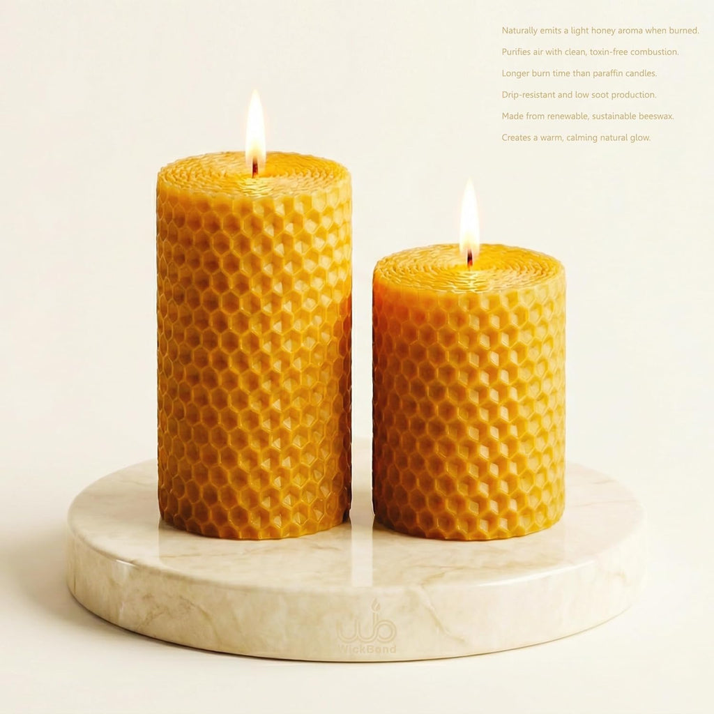 Pair of honeycomb beeswax pillar candles with lit wicks, golden honey color