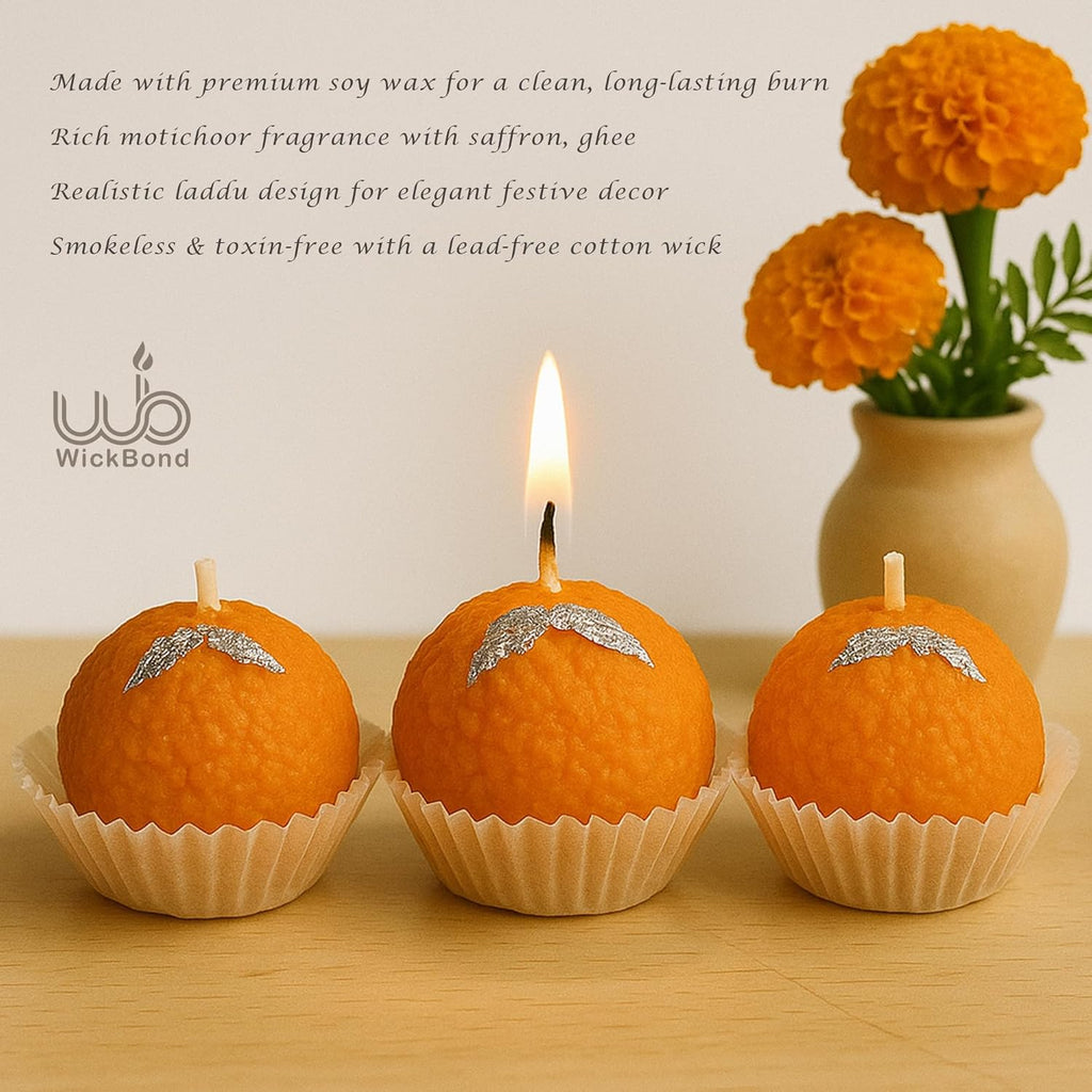 Three Motichoor ladoo candles with flames, orange textured finish in paper cups